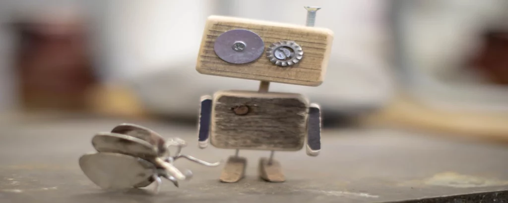 Robot di legno fatto a mano con dettagli in metallo, che metaforicamente rappresenta un chatbot.