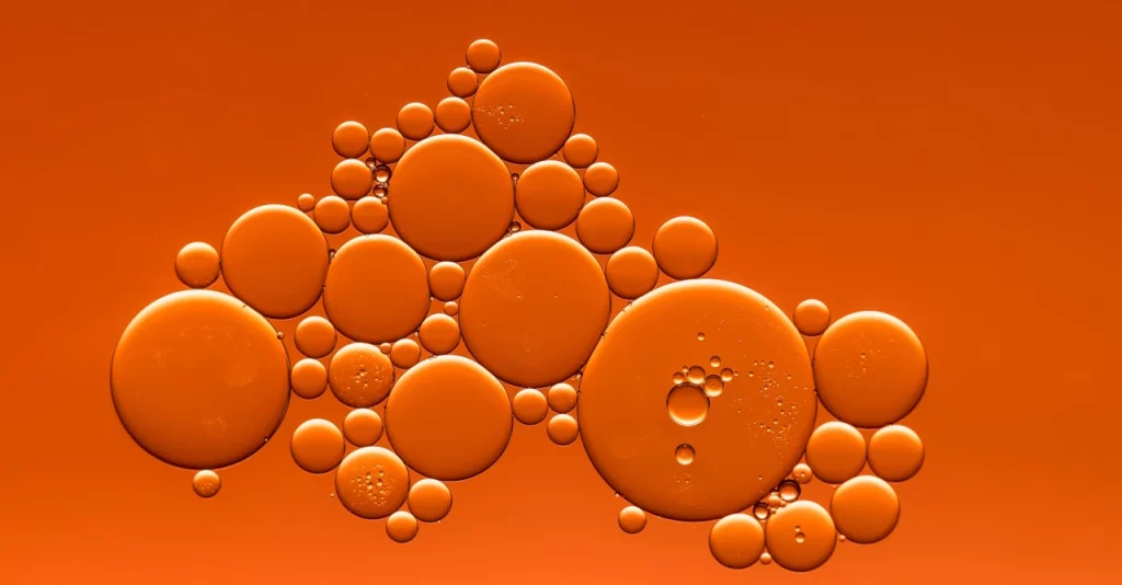 Bolle di diverse dimensioni su sfondo arancione, simboleggiando le microinterazioni nel web design.